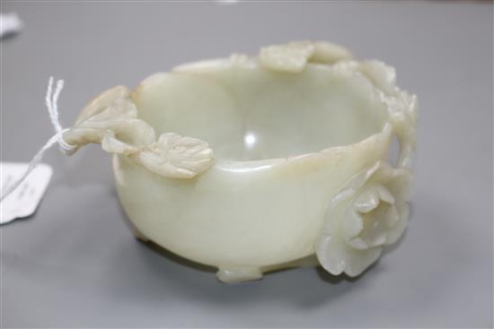 A Chinese pale celadon jade lotus cup, late Ming dynasty, W.13cm, associated wood stand